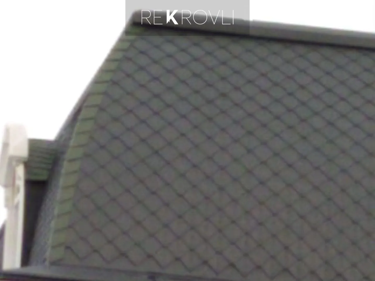 Крупный план серой кровли с ромбовидным рисунком черепицы на крыше дома