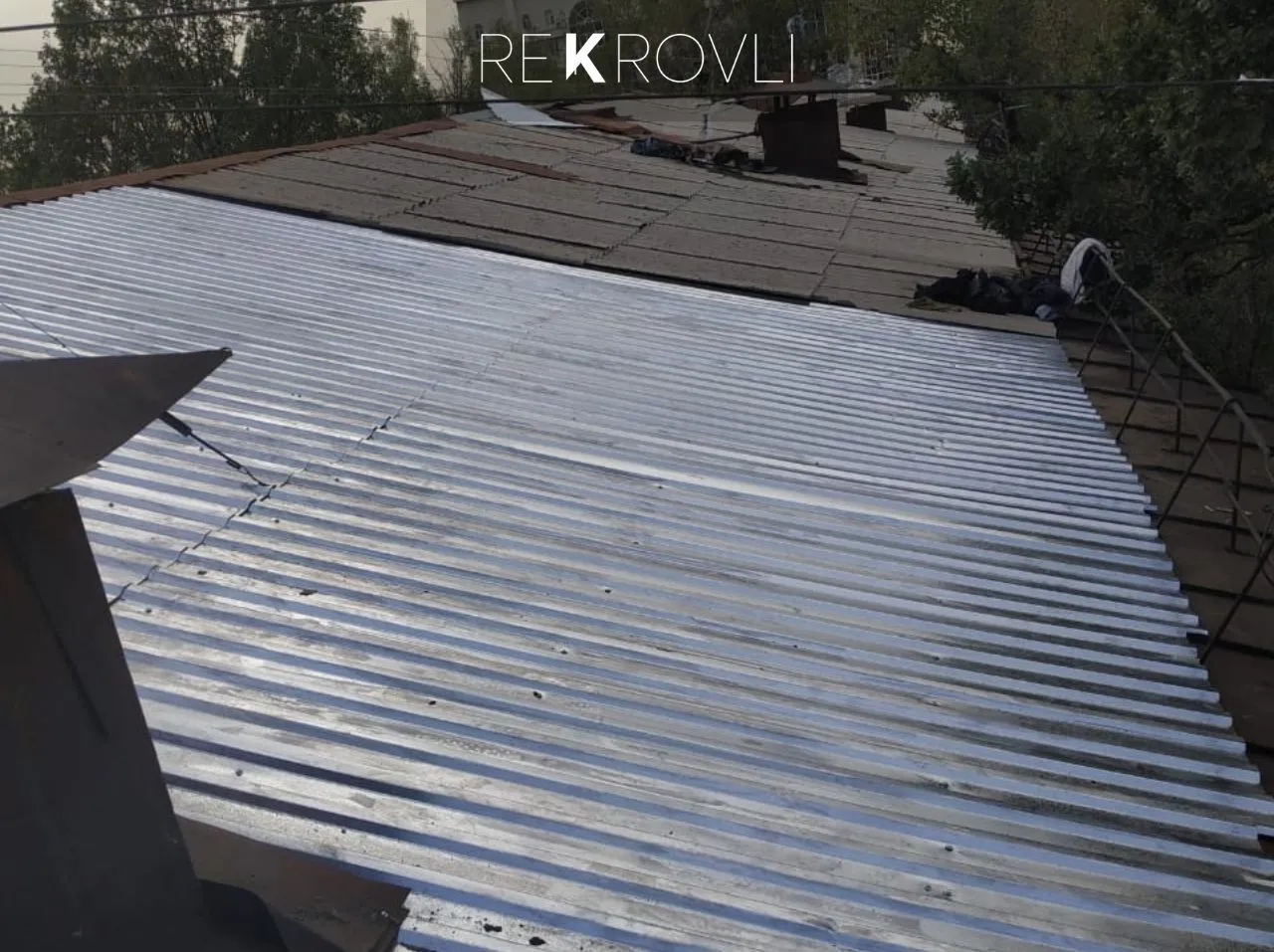 Процесс замены старого кровельного покрытия на оцинкованный профнастил, вид со ската крыши
